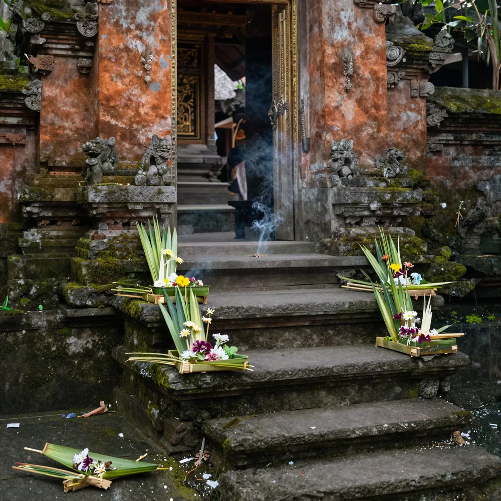 Ofrendas canang sari en los escalones de un templo familiar en Bali